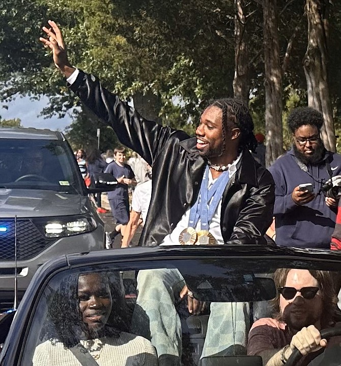 Olympic gold medalist Noah Lyles waves to supporters during a homecoming parade in his honor Sept. 15 in Alexandria. In the front passenger seat is Lyles’ girlfriend Junelle Bromfield, a Jamaican track and field Olympic medalist.