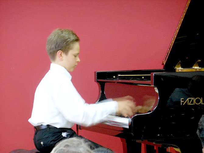 Ten-year-old Anton Nelson’s hands are a blur as he performs at a solo recital Friday, July 6 at The Piano Company in Leesburg.