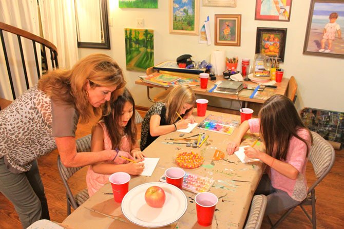 Karen Graham helps Keiko Tani, 10, with her painting at Children’s Studio of Great Falls.
