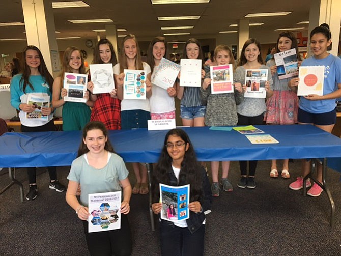 Mrs. Bovenzi’s Quest students at Cooper Middle show off their personalized yearbooks, which they designed using the Adobe Creative Suite.