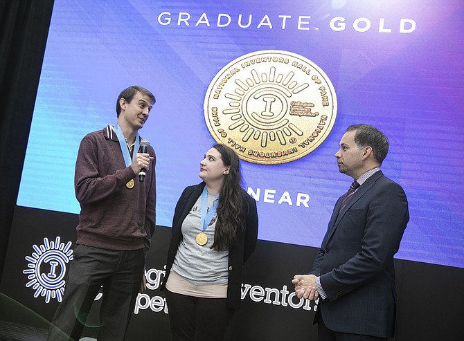 PionEar team members Michael Kreder and Nicole Black speak on stage with Anthony Scardino, USPTO chief financial  officer, after winning the Graduate Division gold medal Nov. 16 at the 2018 Collegiate Inventors Competition.