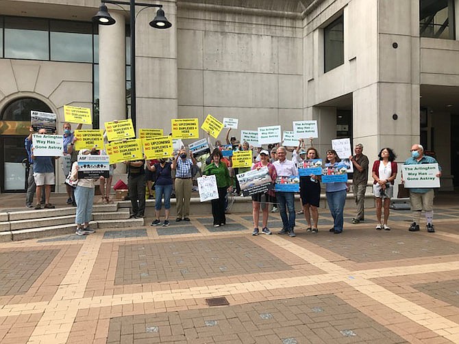 Opponents of Missing Middle Housing Proposal hold signs before a County Board meeting in 2022: “No upzoning; no duplex here.”