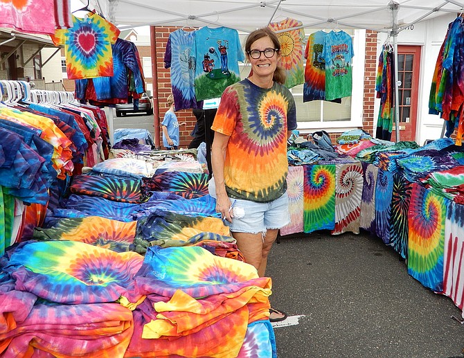 A vendor selling tie-dyed shirts at a past festival.