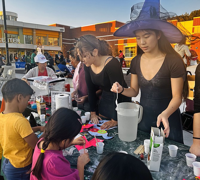 Costumed witches demonstrate a science experiment during the ninth annual Spooky Mad Science Expo Oct. 19 at Patrick Henry Recreation Center.