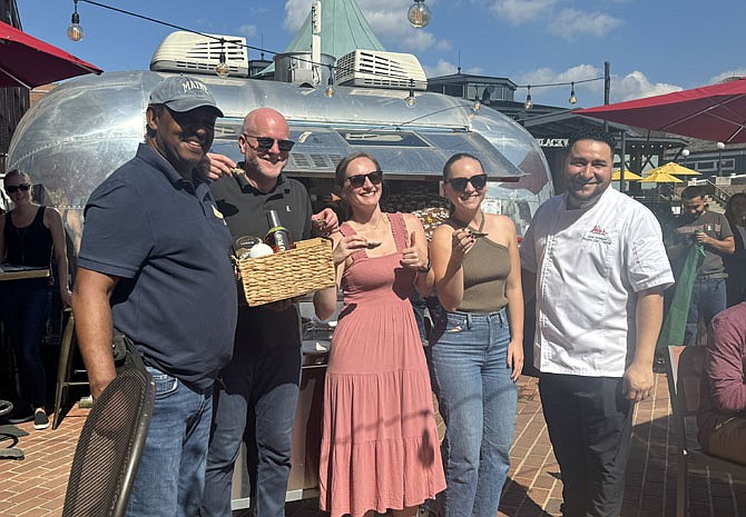 Levin Kates, left, won the oyster shucking contest at Vola’s Oyster Fest Oct. 5 at the City Dock. At right is Vola’s executive chef Javier Rodriguez.