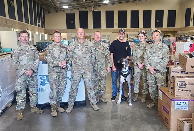 Eric Parkhurst and his dog Roscoe with some North Carolina National Guard members on Oct. 21 after delivering needed supplies.