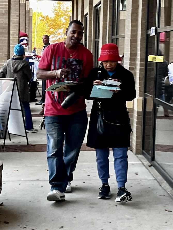 Voters begin to read through the campaign literature and unofficial sample ballots outside the polling location on Nov. 5, Election Day 2024.