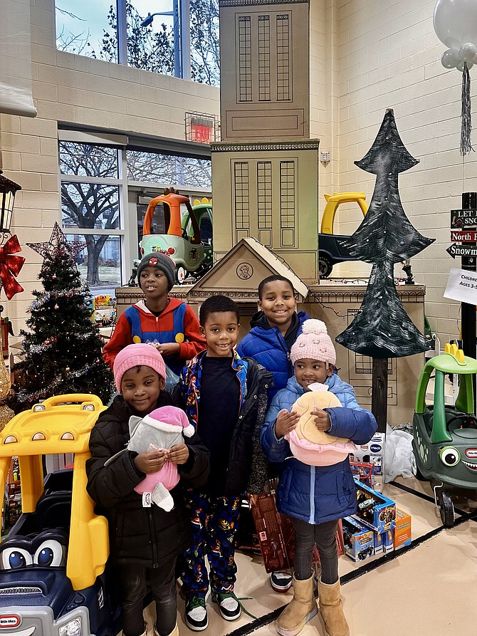 Children pose for a photo in front of a replica of the George Washington Masonic National Memorial during the ARHA Winter Wonderland Dec. 13 at the Charles Houston Recreation Center.