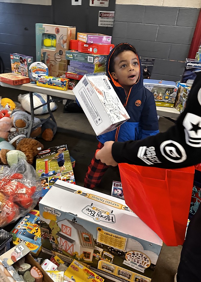 A young boy selects a toy as part of the Firefighters and Friends annual toy distribution Dec. 16 at Penn Daw Station 11.