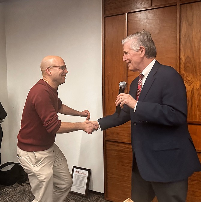 Rep. Don Beyer, right, congratulates Justin Wilson at a roast of the outgoing mayor Dec. 15, 2024.