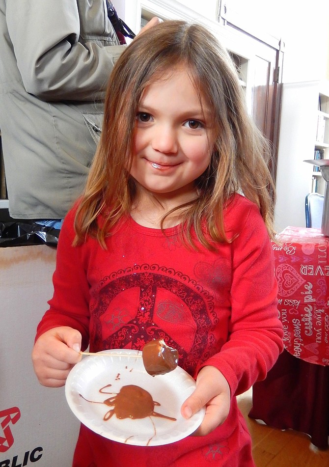 Caitlyn Schawalder, proudly displays her chocolate-drenched marshmallow at a previous Chocolate Lovers Festival.