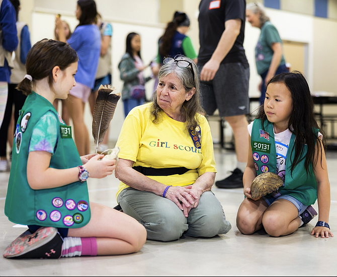 Girl Scout leader Linda Kuzmack listens to a young girl scout from a McLean troop share her ideas about a March 31 service unit project, during the project preparation stage.