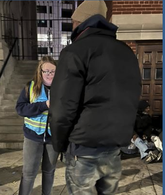 Survey volunteers and outreach workers, like the woman in the blue vest, interview people experiencing homelessness during the Point-in-Time Count.