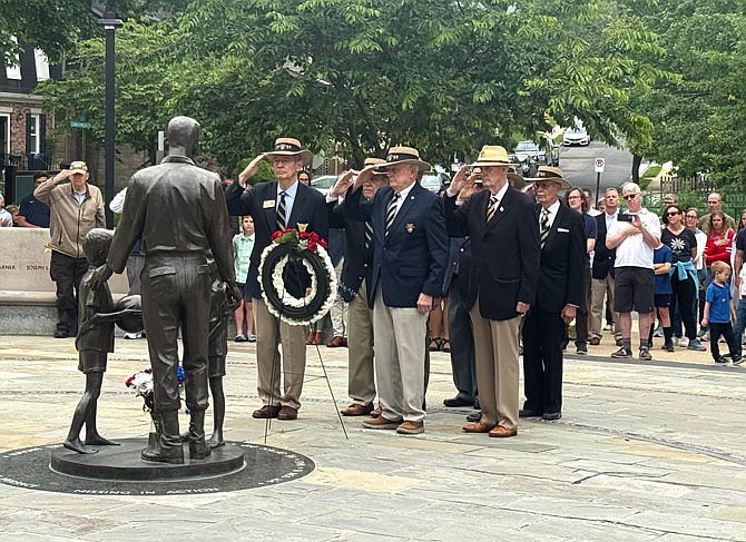 Classmates of Rocky Versace’s West Point Class of 1959 salute during the playing of TAPS after placing a Wreath at the Rocky Versace statue May 26 in Del Ray.