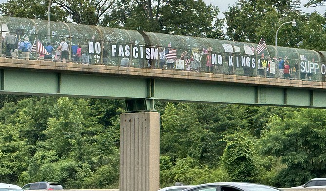 Protestors line I-495 overpass with No Kings and other resistance messaging