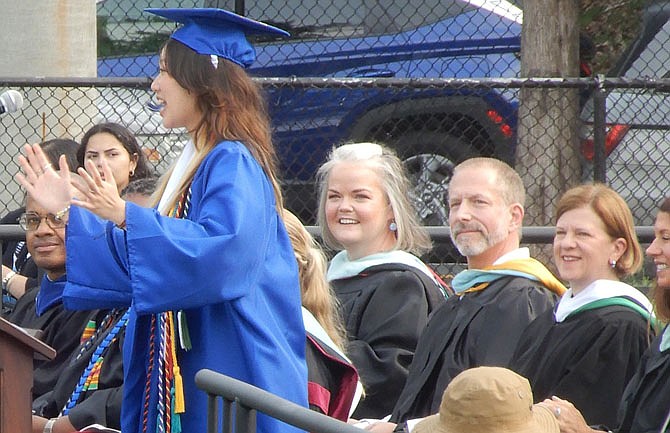 Listening while Honor Graduate Vy Tran addresses her classmates are (from far left) Fairfax City Public Schools Chief of Schools Geovanny Ponce, teachers Cheryl Spevak and Pete Peterson, Mayor Catherine Read and City School Board Chairman Carolyn Pitches.