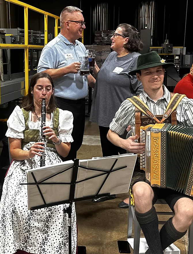 Jim and Karen Zalewski toast as musicians with M+J Volksmusik perform at the Senior Services of Alexandria Oktoberfest Oct. 8 at Port City Brewing Company.