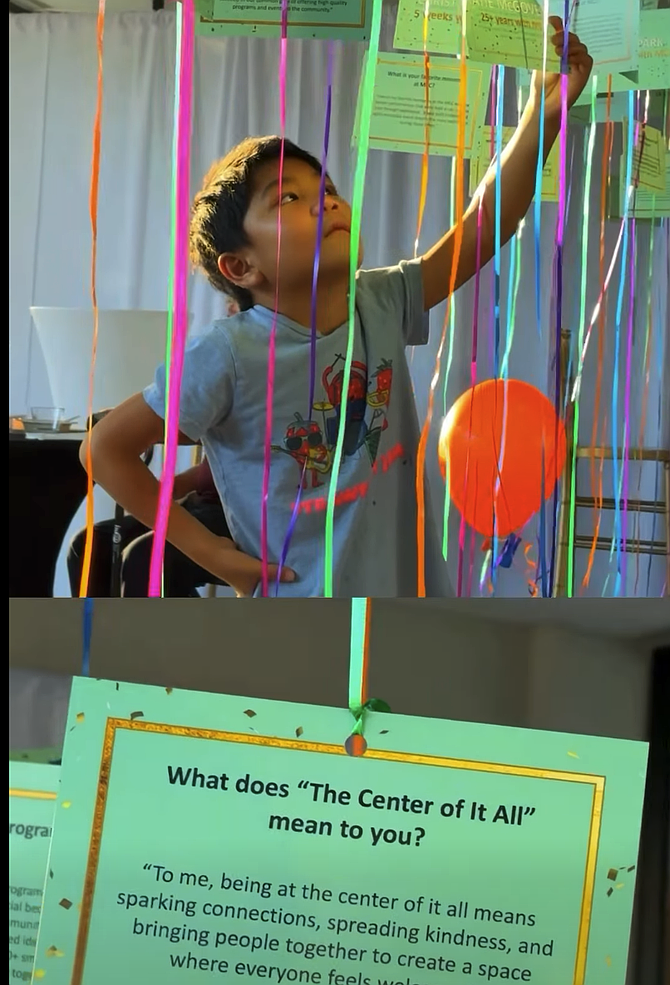 A young boy reads the notes from the 50th Anniversary Memory Board.