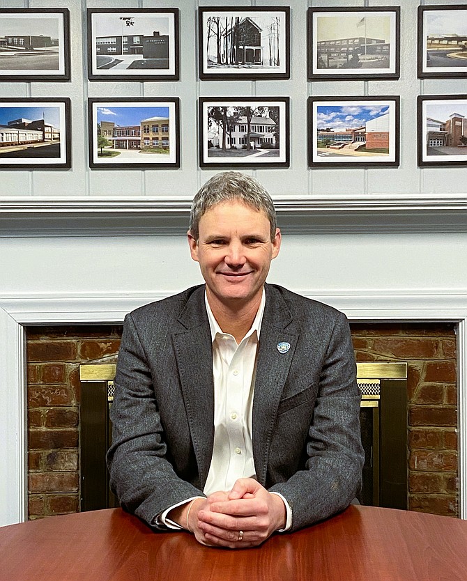 Dustin Wright with vintage photos of Fairfax City schools above him.