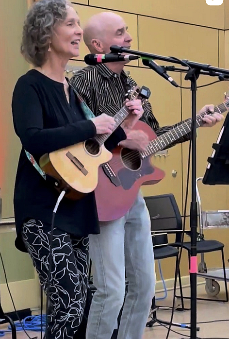Local contemporary folk artists, Ann Granger and Larry Rice, perform at the Arlington Acoustic Cafe at Walter Reed Community Center on Dec. 17, 2024. The duo appeared as part of a monthly concert series held on the first Tuesday of each month to showcase local talent. Less than a year later, they dominate The Roots Music Report’s national charts for the week of Nov. 22, 2025.