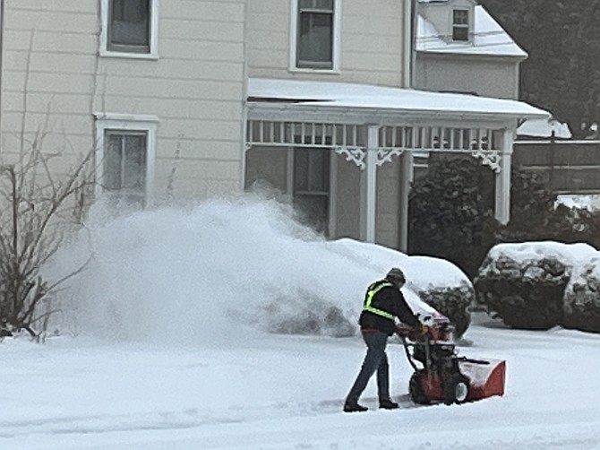 Day 1, Jan. 25: A Town of Herndon resident uses a snowblower to clear a sidewalk for his neighbors Sunday, Jan. 25. Sleet was just beginning to fall as the region transitioned from snow to historic ice storm.