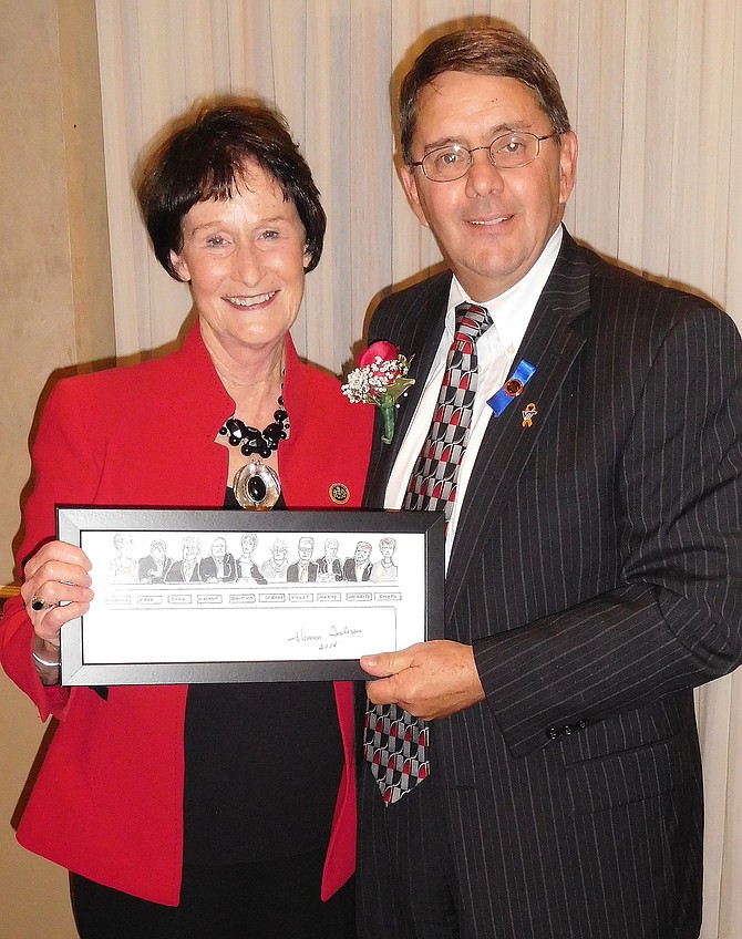 Sharon Bulova gives Michael Frey a hand-drawn sketch of the Board of Supervisors as a retirement gift.