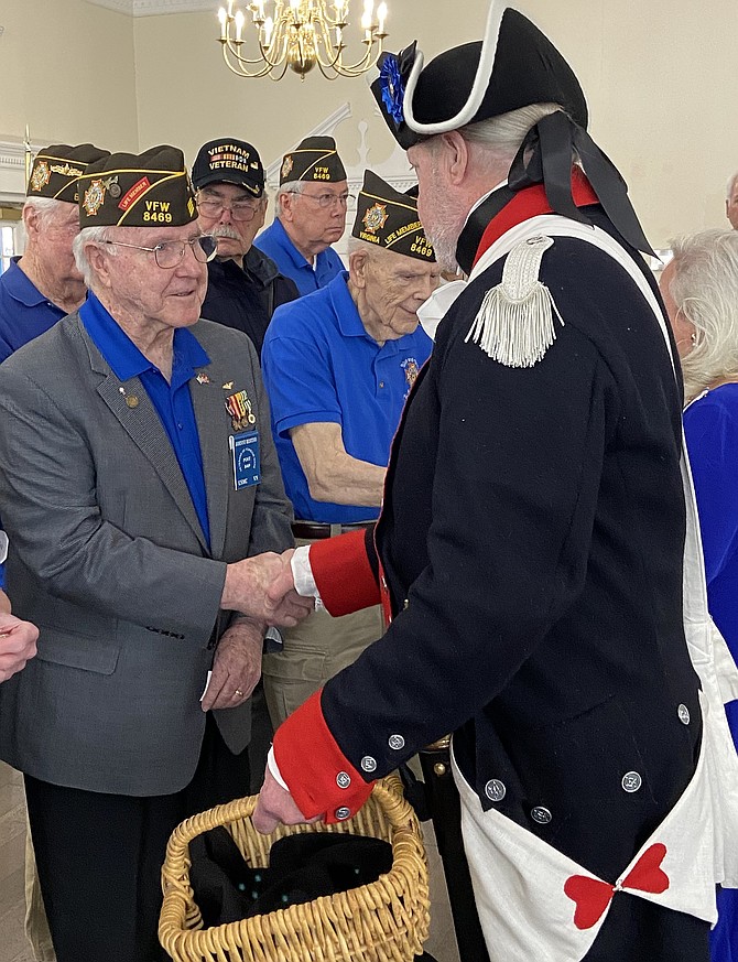 From left, VFW’s Johnny Restivo and Jim Cordes shake hands as Cordes presents Restivo with a Vietnam veterans lapel pin.