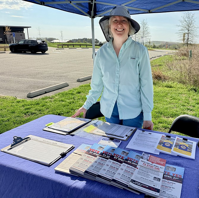 Political organizer Elizabeth Ferrara of Alexandria provides voting information at a pick-up point in Lorton for door-knocking campaigns to get out the YES vote