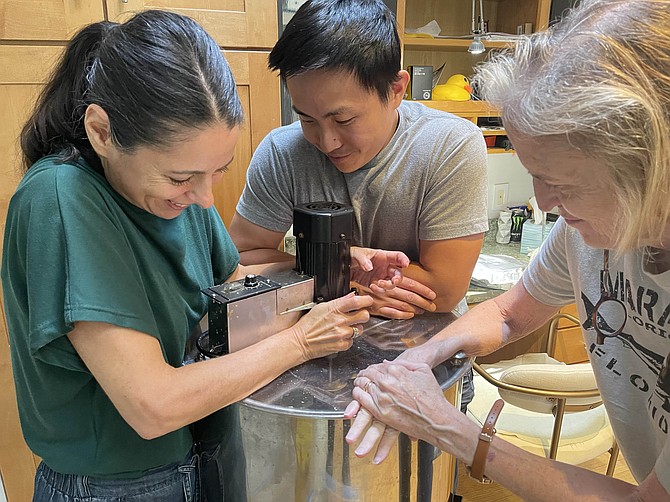 Nevra and two helpers, Michael and Kathleen, hold down the juggling extractor.