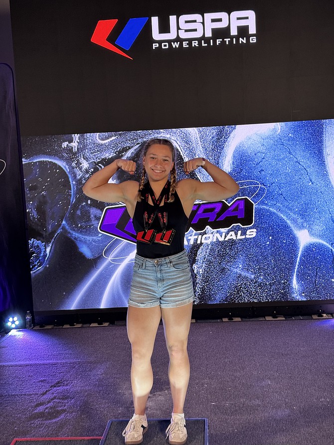 Mikayla Dolina of McLean shows her muscles at the United States Powerlifting Association Ultra Nationals in Anaheim, California. She broke three International Powerlifting League Junior world records.