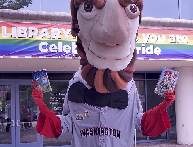 Abe from the Washington Nationals famed President’s racing team, holds up two of his favorite summer reading choices.
