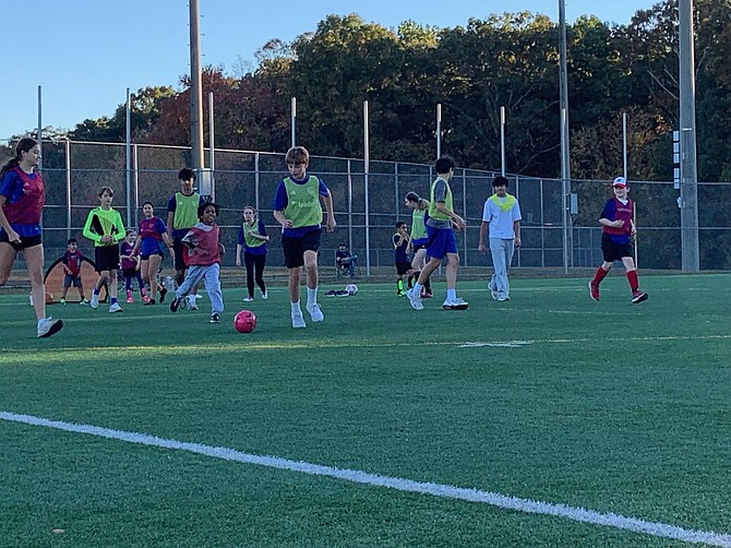 Athletes and volunteer buddies run through drills during a TOPSoccer practice at Great Falls Reston Soccer Club.