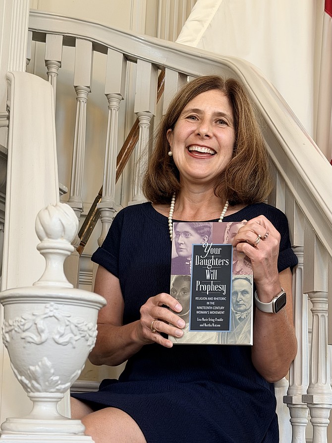 Author Lisa Marie Gring-Pemble holds the book she authored with college and friend Martha Watson.