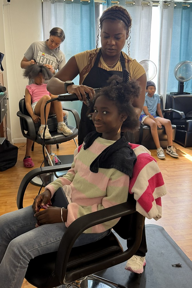 Khadija Yahya gets a haircut from stylist Nickie Wedderbum Aug. 18 at Iye Beauty Salon.